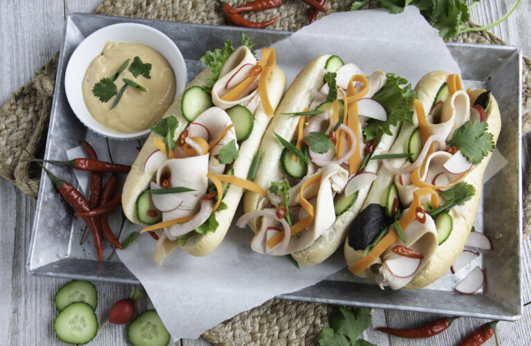 3 Bahn Mi sandwiches with colorful vegetables and Farmers and Cooks turkey