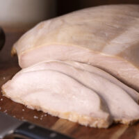 Sliced Farmers & Cooks Simple Roast Turkey on wooden cutting board